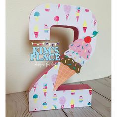 the number two is decorated with ice cream and sprinkles