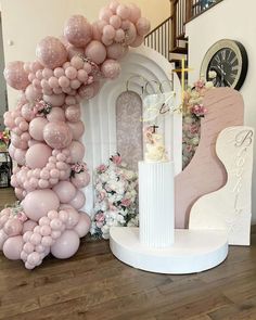 the balloon arch is decorated with pink and white balloons, along with a wedding cake