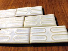 four white tiles sitting on top of a wooden table