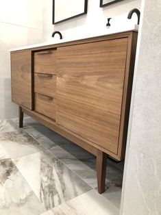 a bathroom with two sinks and a wooden cabinet