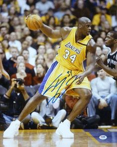 a basketball player dribbling the ball in front of an audience at a game