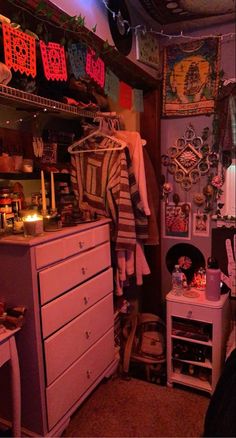 a room with lots of clutter on the floor and clothes hanging up in it