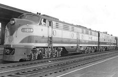 black and white photograph of a train pulling into a station