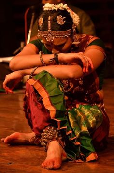 a woman sitting on the floor with her arms crossed