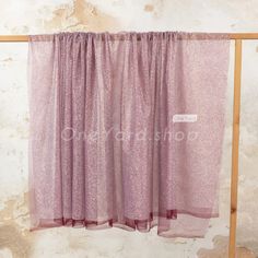 a purple curtain hanging on the side of a wall