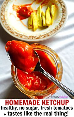 a spoon full of ketchup sitting on top of a table next to a plate