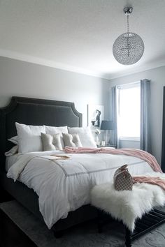 a bed with white sheets and pillows in a bedroom next to a window, rugs on the floor