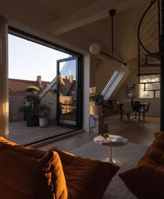 a living room filled with furniture and a spiral staircase leading up to the top floor