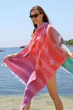 a woman is walking on the beach with a towel