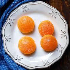 three oranges are on a white plate