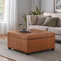 a living room with a couch, chair and ottoman on the floor in front of a window