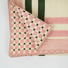 a pink and black checkered blanket laying on top of each other