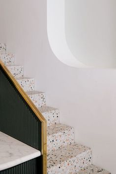 the stairs are white with black dots on them and there is also a gold handrail