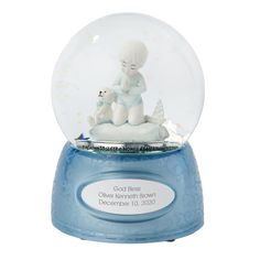 a snow globe with a person sitting in it on top of a blue base holding a white dog