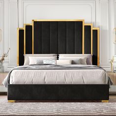 a bed with black and gold headboard in a white walled room, surrounded by art deco furniture