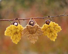 three leaf shaped ornaments hanging from a twig