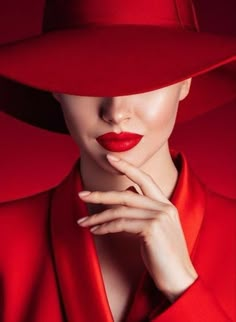 a woman wearing a red hat with her hand on her chin