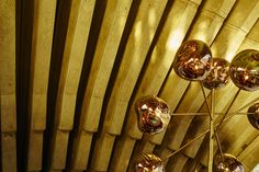 a chandelier hanging from the ceiling in a room with wooden slatted walls