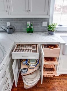 an open drawer in the middle of a kitchen