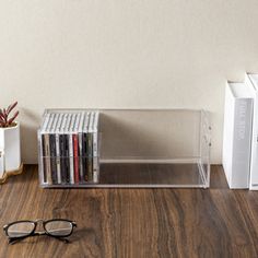 a pair of glasses sitting on top of a wooden table next to a stack of books