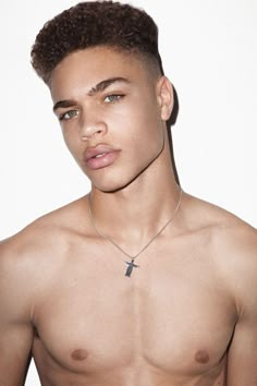 a shirtless young man wearing a cross necklace