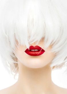 a woman with white hair and bright red lipstick on her lips is shown from the side