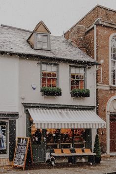 a store front with snow falling on the ground