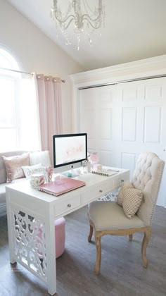 a white desk with a computer on top of it next to a chair and window