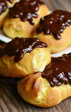 chocolate covered pastries sitting on top of white plates