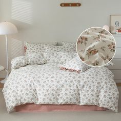 an image of a bedroom setting with flowers on the comforter and bed linens