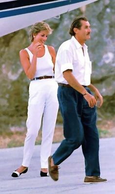 a man and woman walking towards an airplane