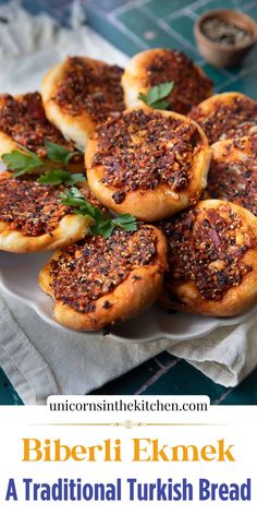 some breads are sitting on a white plate and have been topped with seasoning