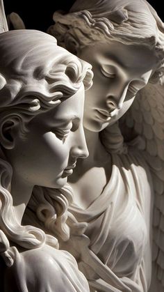 two white statues with angel wings next to each other, one holding the other's head