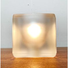 a square light sitting on top of a wooden table