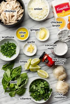 ingredients to make chicken broth laid out on a marble counter top, including onions, spinach, garlic, onion, and seasoning