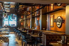 the interior of a restaurant with wooden tables and leather booths on either side of the dining room