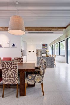 the dining room table is surrounded by matching chairs and upholstered armrests