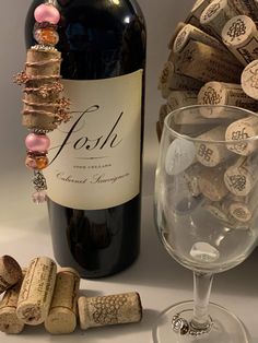 a bottle of wine and some corks on a table next to a glass filled with wine