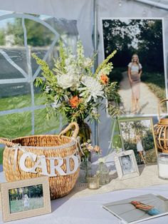 a table topped with pictures and flowers next to a basket filled with flowers on top of a table