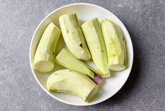 sliced green apples in a white bowl on a gray table top, ready to be eaten