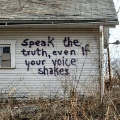 graffiti on the side of a white house reads speak the truth, even your voice shakes