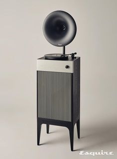 an old record player sitting on top of a wooden cabinet with a black and white design