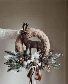 an ornament with a deer and pine cones on it is hanging from the ceiling