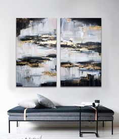 two paintings on the wall above a couch in a white room with black and gold accents