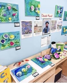 art work is displayed on the wall in front of children's artwork and crafts