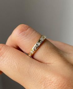 a woman's hand with a diamond ring on her left finger and the other hand holding it