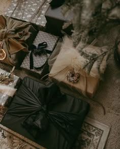 presents wrapped in black paper and tied with ribbons, sitting on the floor next to a christmas tree