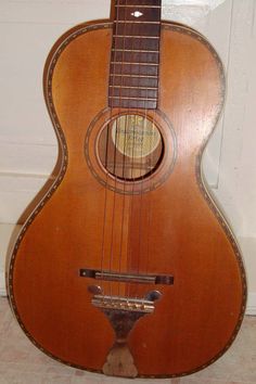 an old acoustic guitar sitting on the floor