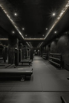 an empty gym with rows of benches and lights on either side of the room,