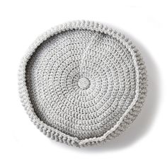 a white crocheted basket sitting on top of a table